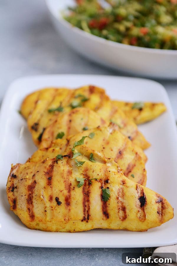 Creamy Thai Coconut Grilled Chicken 2 A white platter filled with grilled chicken, sprinkled with cilantro.