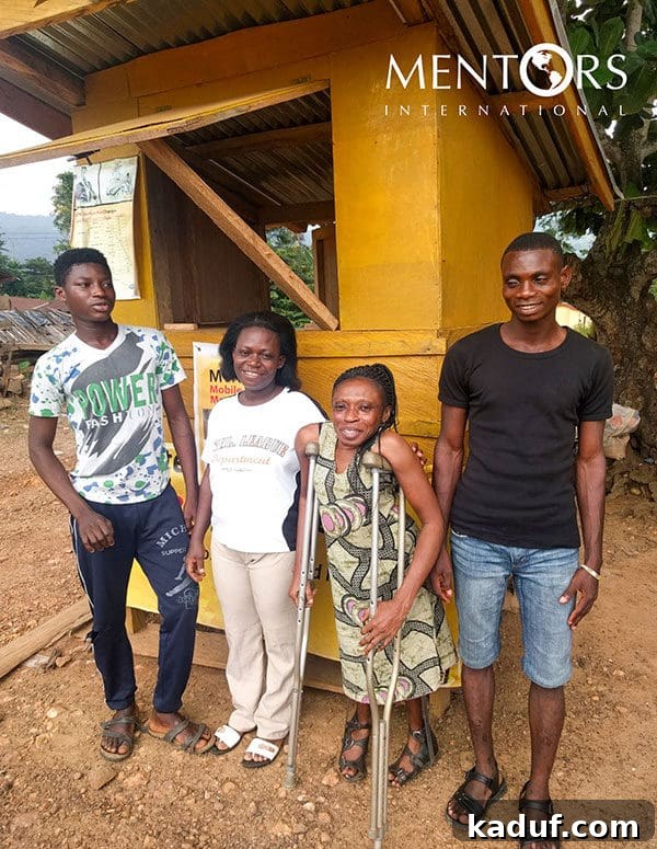 Naomi proudly standing in her thriving village store, showcasing increased inventory and entrepreneurial success.