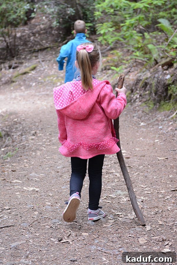 The Laid-Back Guide to Redwood National Forest 16 A little girl hiking with a walking stick, showing determination on the trail.