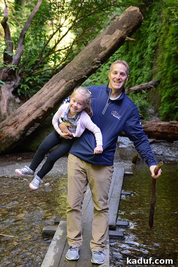 The Laid-Back Guide to Redwood National Forest 19 A Dad holding his daughter and crossing a wooden bridge in Fern Canyon, illustrating the interactive trail.