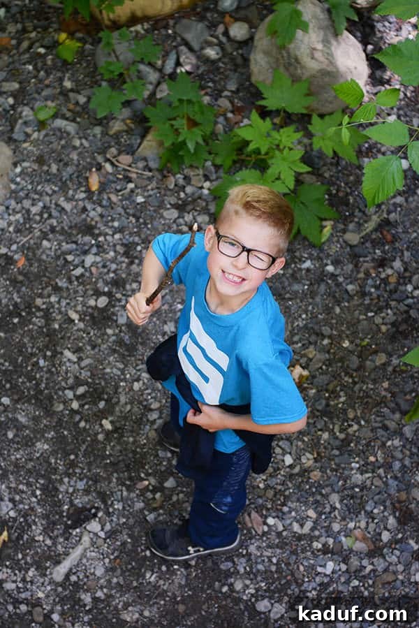 The Laid-Back Guide to Redwood National Forest 27 A little boy with glasses holding a stick and winking at the camera in the Redwood forest.