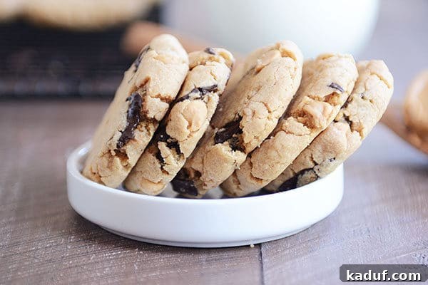 Five soft peanut butter chocolate chip cookies stacked side-by-side in a white ramekin.
