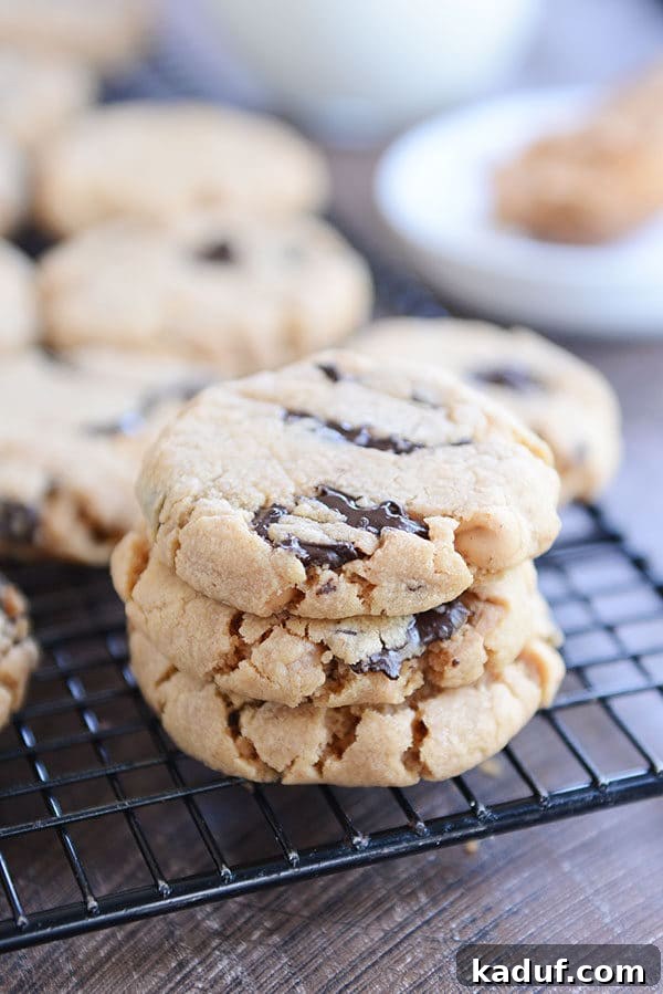 A stack of soft and chewy peanut butter chocolate chip cookies on a cooling rack.