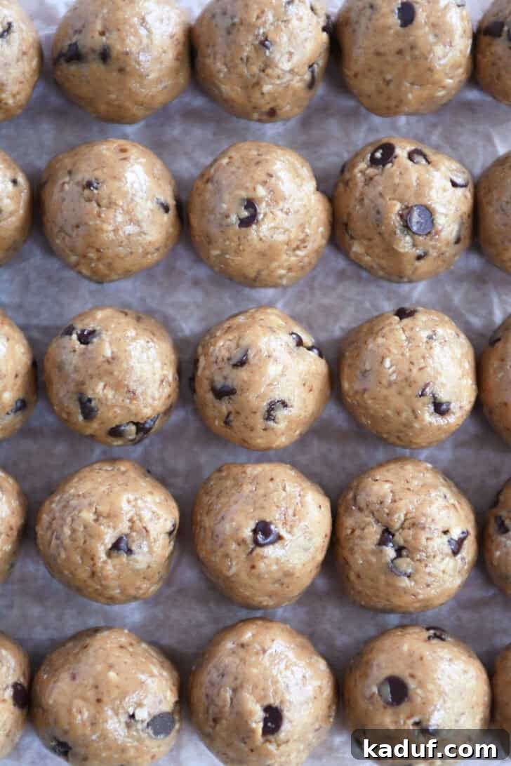 Delicious Protein Bites: Tailored to Your Taste 6 Top-down view of perfectly rolled chocolate chip peanut butter balls arranged on a sheet of wax paper.
