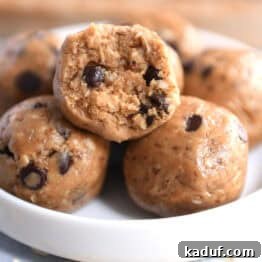 Soft peanut butter chocolate chip balls in a small white dish, with a bite taken out of the top one. A delicious and healthy snack.