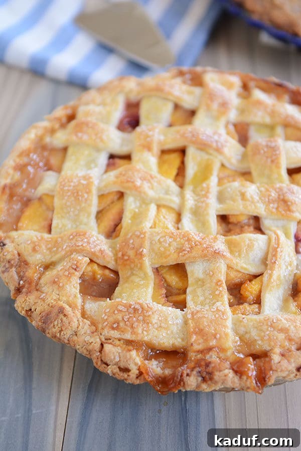 Summertime Peach Pie Perfection 2 A beautifully crafted lattice-topped fresh peach pie, showcasing its golden crust and juicy filling.