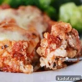 Mom's Signature Lasagna 4 A perfectly baked slice of lasagna with a crisp top, ready to be served from a white plate.