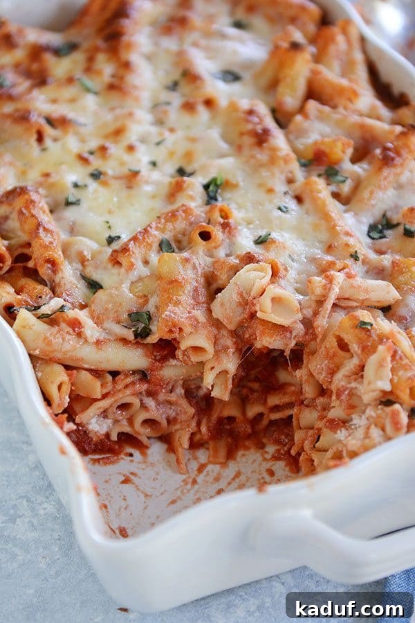 Hearty Make-Ahead Cheesy Baked Ziti 2 A casserole dish of cheesy baked ziti with a scoop taken out of the corner.