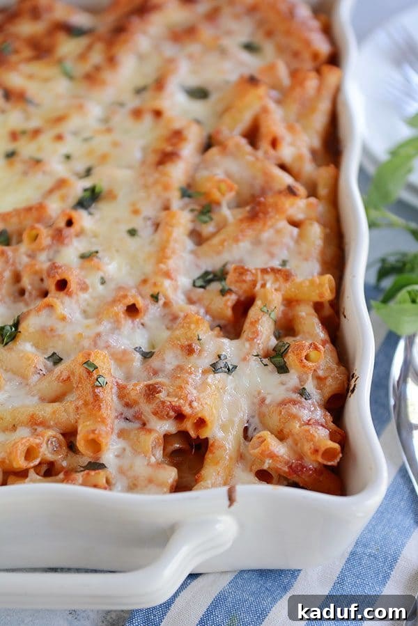 Hearty Make-Ahead Cheesy Baked Ziti 4 A white casserole dish full of cheese-topped baked ziti sprinkled with cilantro.