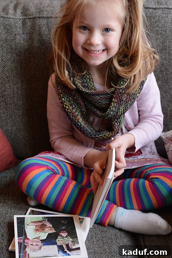 A little girl engrossed in reading books on a cozy couch, enjoying quiet time.