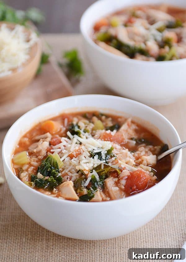 Versatile Poultry and Brown Rice Soup 6 Turkey, vegetable, and brown rice soup topped with parmesan cheese in a white bowl.