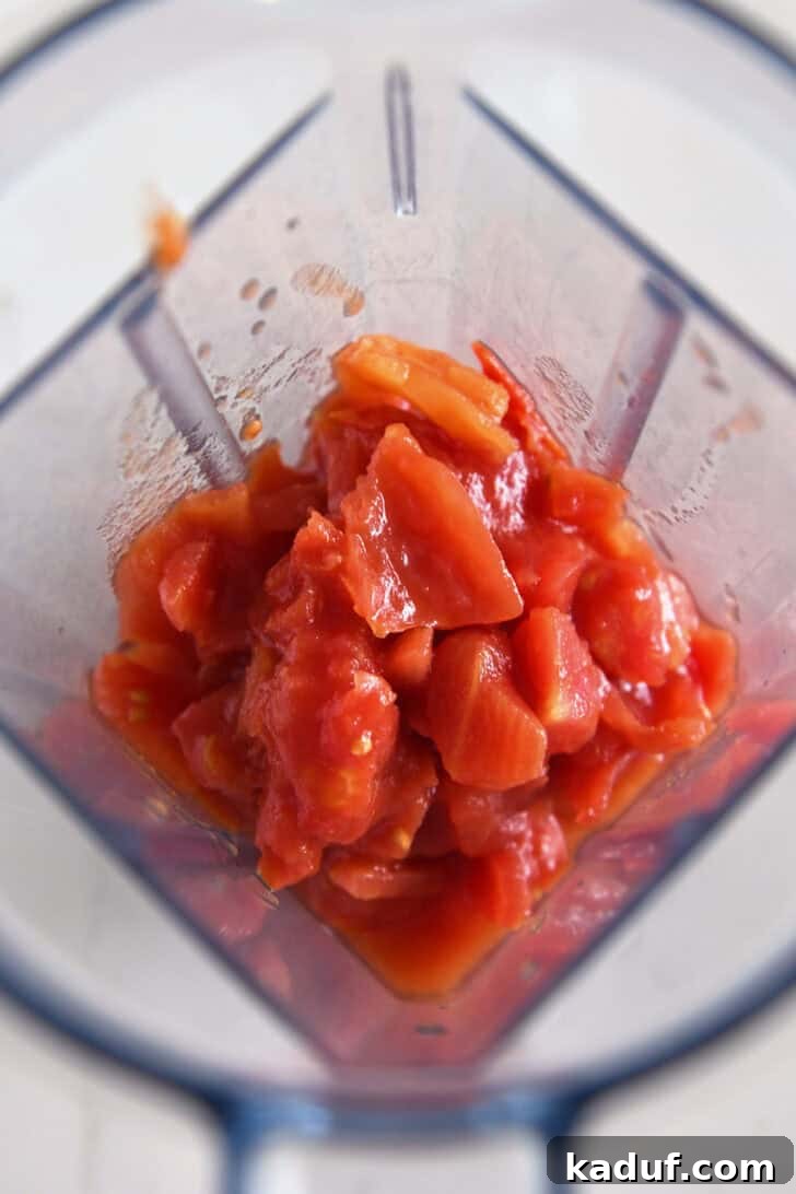 Effortless Homemade No-Cook Pizza Sauce 3 Diced tomatoes being added to a blender, ready for blending into sauce.