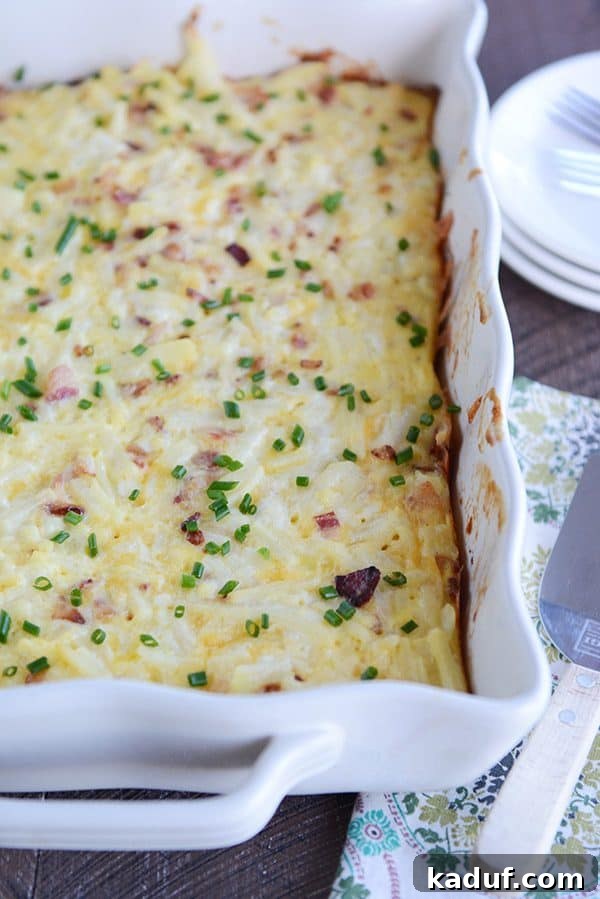 Rich Cheesy Hash Brown and Egg Overnight Bake 4 A white dish full of cheesy egg casserole sprinkled with green onion.