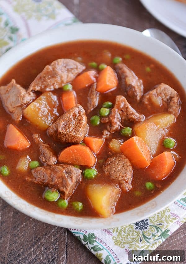 Meltingly Tender Instant Pot Beef Stew 5 A cozy bowl brimming with Instant Pot beef stew, perfectly cooked beef, carrots, potatoes, and peas visible in the rich broth.