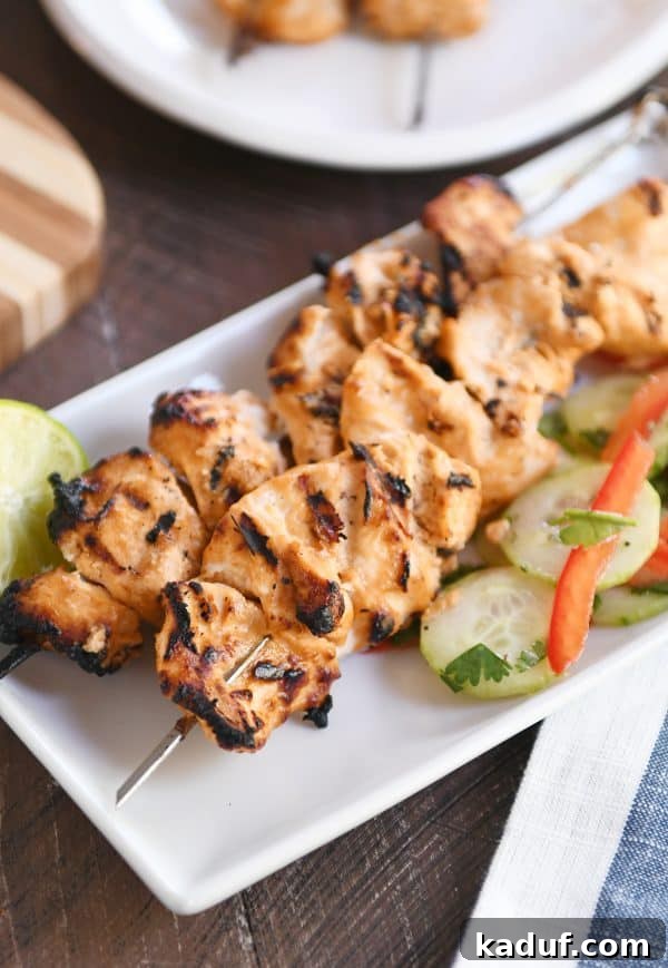 Creamy Almond Coconut Chicken Satay 2 Grilled Almond Coconut Milk Chicken Satay with Quick Cucumber Salad on a white platter.