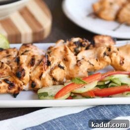 Cucumber salad with almond coconut milk chicken satay on white platter.