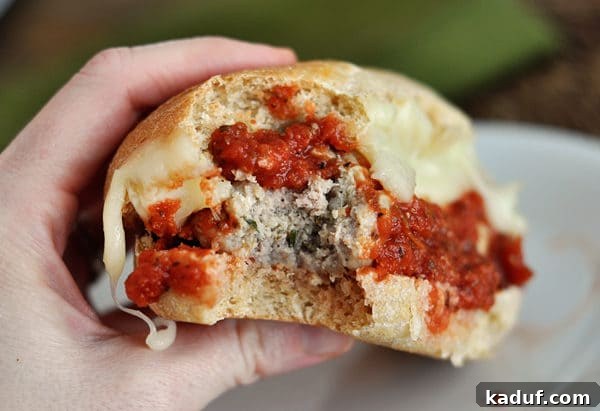 bite taken out of an italian meatball and cheese sub sandwich