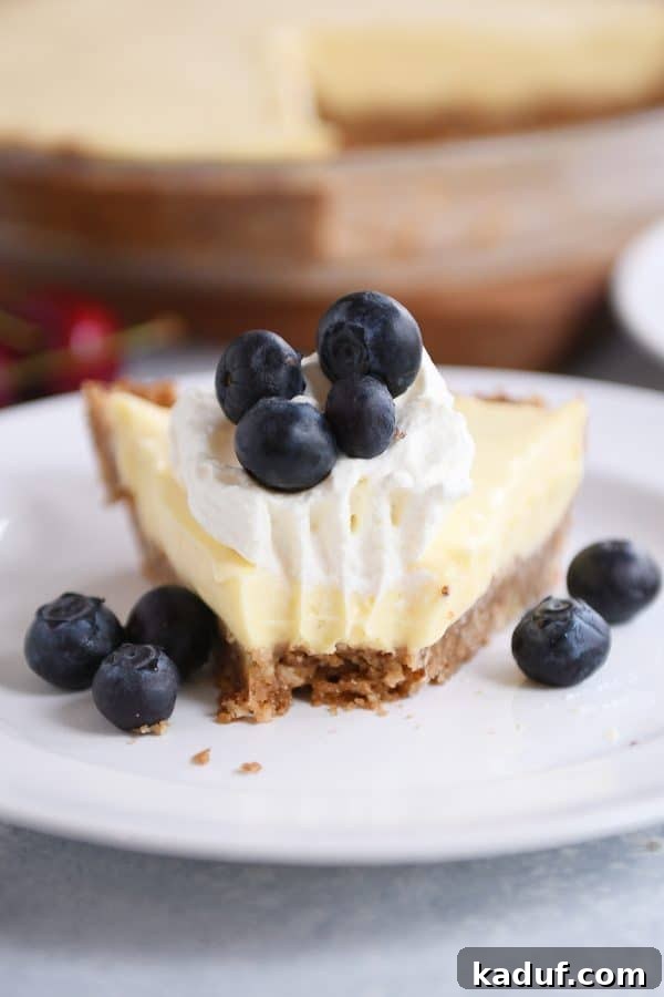 Creamy Berry Delight Pie with Toasted Pecan Graham Crust 2 A slice of berries and cream pie on a white plate with a bite taken out.