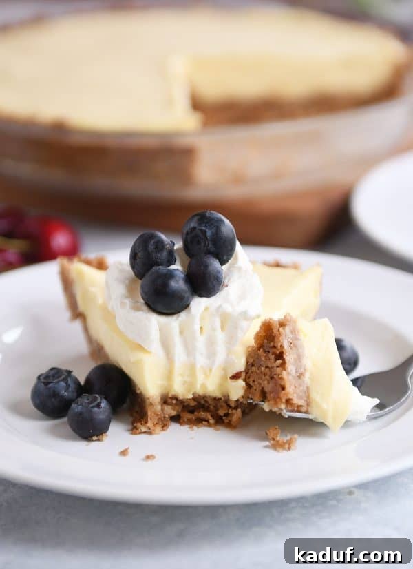 Creamy Berry Delight Pie with Toasted Pecan Graham Crust 5 Berries and cream pie on a white plate with a bite taken out.