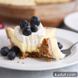 Creamy Berry Delight Pie with Toasted Pecan Graham Crust 6 Berries and cream pie on a white plate with a bite taken out.