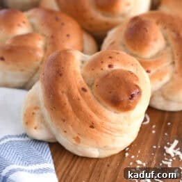 Quick Cheesy Parmesan Knots 13 Several baked Parmesan breadstick knots on a wooden board with a white and blue cloth, beautifully arranged and ready to be served.