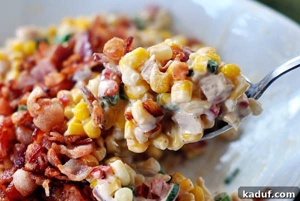 My Signature Thanksgiving Spread 3 A spoon delicately taking out a bite of rich, creamy corn topped with crispy, savory bacon. A beloved side dish for any holiday gathering, offering comforting flavors.