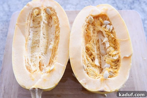 Effortless Weeknight Spaghetti Squash Casserole 5 Halved spaghetti squash with seeds visible, demonstrating preparation before cooking.