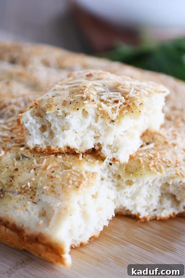 Super Simple Hand Mixed Focaccia 2 Easy focaccia bread with piece on top of loaf.