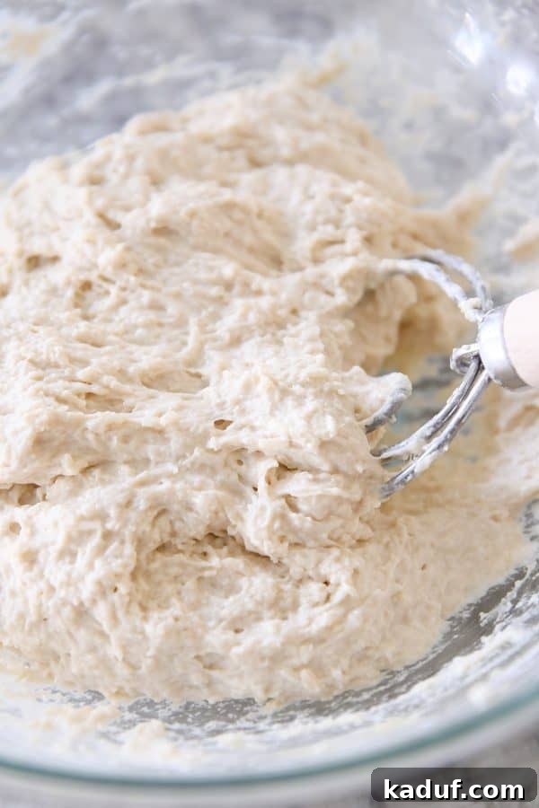 Super Simple Hand Mixed Focaccia 4 Mixing dough for easy focaccia bread in glass bowl.