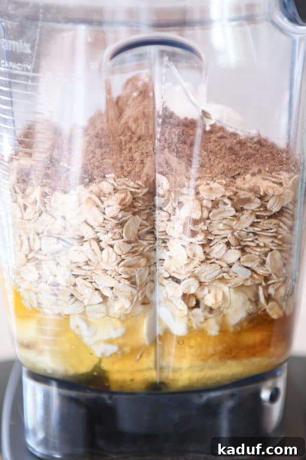 Gluten-Free Double Chocolate Banana Blender Muffins 4 Preparing muffin batter in blender with eggs, oats, cocoa powder.