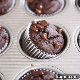 Double chocolate banana blender muffin propped on side in metal tin.