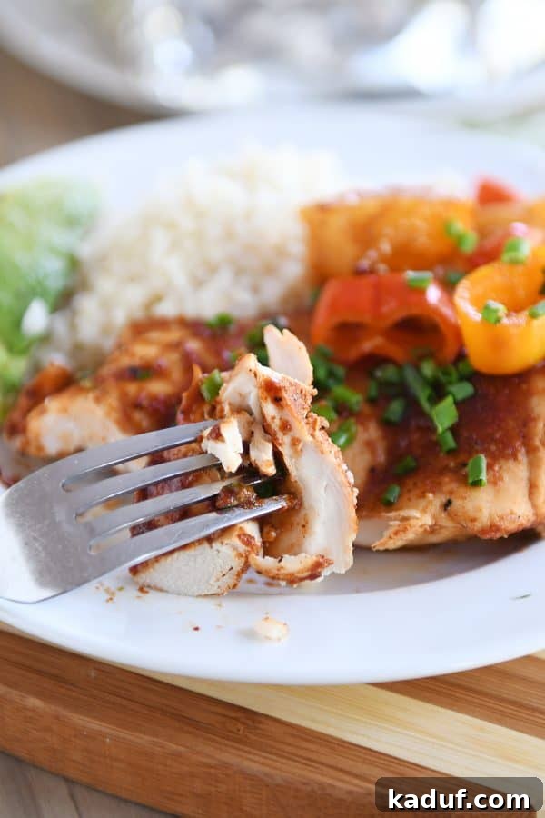 Tropical BBQ Chicken Foil Dinners 3 A fork lifts a bite of BBQ Hawaiian chicken, peppers, and pineapple from a plate, demonstrating the tender texture of the ingredients and inviting you to try.
