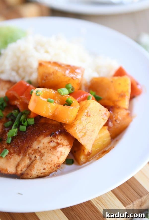 Tropical BBQ Chicken Foil Dinners 6 A beautifully plated BBQ Hawaiian Chicken foil packet meal served alongside fluffy cauliflower rice on a clean white plate, garnished with fresh herbs.