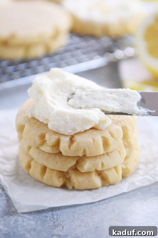 Stack of three lemon swig sugar cookies with pile of frosting on top.