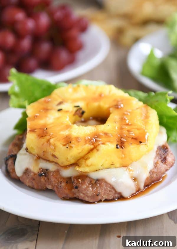 Tropical Teriyaki Turkey Burgers with Grilled Pineapple 3 Bun-less Teriyaki Turkey Burger topped with grilled pineapple and melted Swiss cheese, showcasing its delicious layers.