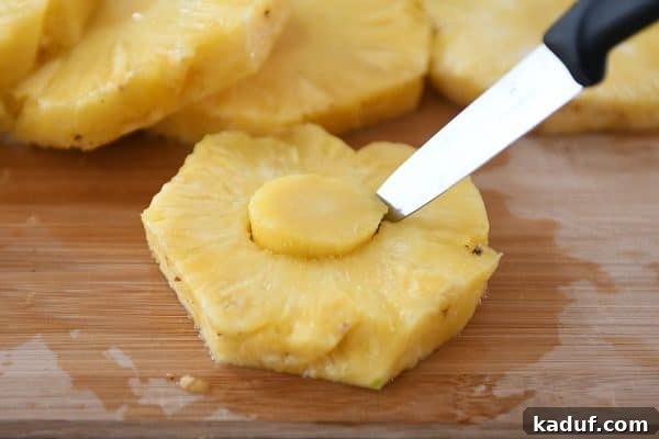 Tropical Teriyaki Turkey Burgers with Grilled Pineapple 4 Expertly cutting out the tough core from a fresh pineapple slice, preparing it for grilling.