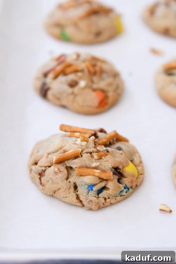 Peanut Butter Cosmic Crunch Cookies 3 Baked peanut butter kitchen sink cookie on white parchment paper.