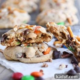 Peanut Butter Cosmic Crunch Cookies 10 Baked peanut butter kitchen sink cookies with one broken in half.