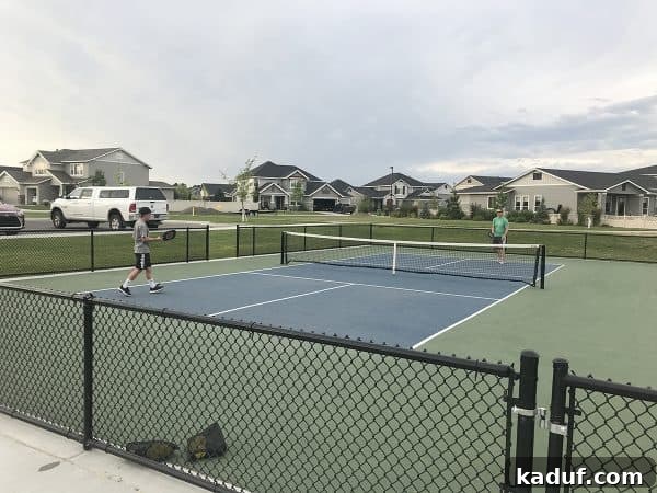 Friday Focus: Mastering the Summer Months 13 A family playing pickleball on an outdoor court, enjoying the fast-paced and fun sport together.