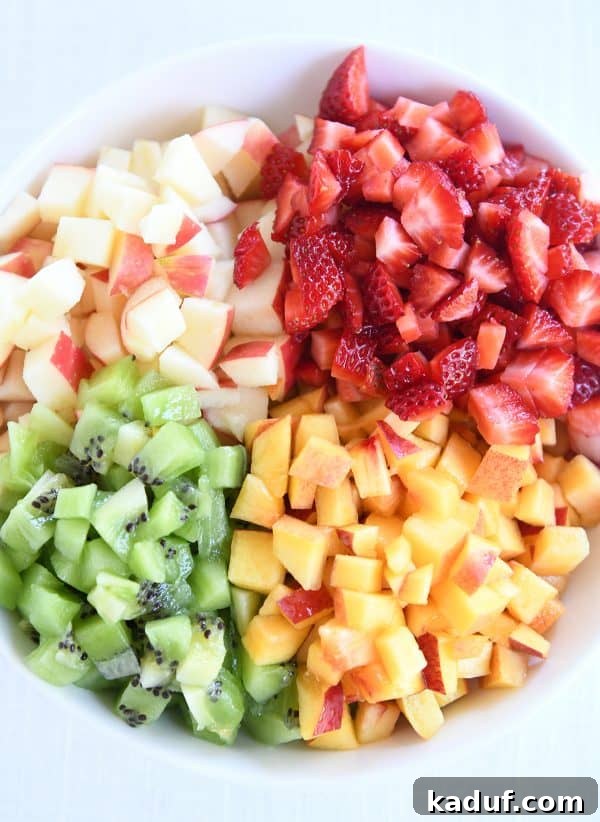 Vibrant Fruit Salsa with Honey-Kissed Cinnamon Crisps 4 White bowl with diced apples, kiwis, peaches and strawberries.