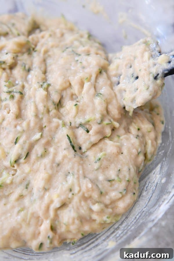 Moist Zucchini Banana Bliss 5 Glass bowl containing thoroughly mixed zucchini banana bread batter, ready for baking.