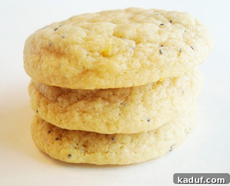 Bright Lemon Poppy Seed Delights 3 A stack of golden lemon poppy seed cookies on a white plate.