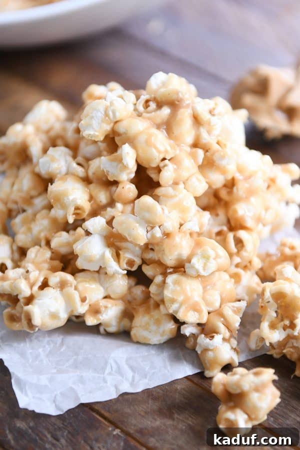 Gooey Peanut Butter Popcorn Bliss 11 A generous pile of soft and chewy peanut butter caramel popcorn resting on wax paper, ready for serving or packing.