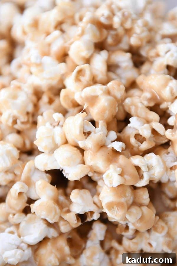 Gooey Peanut Butter Popcorn Bliss 4 A close-up view of soft and chewy peanut butter caramel popcorn, showcasing its glossy, textured coating and inviting appearance.