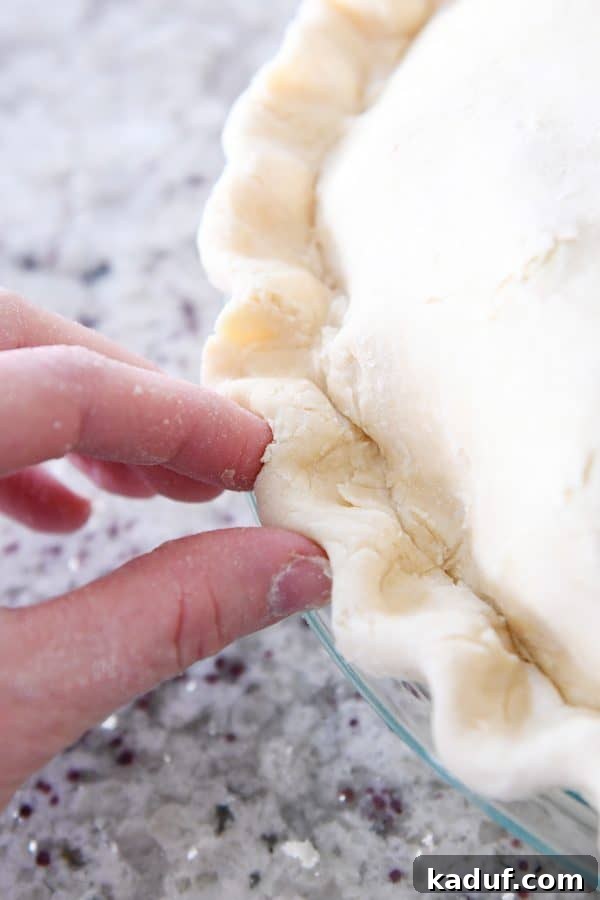 Thanksgivings Beloved Apple Cranberry Pie 11 Crimping edges of double pie crust.