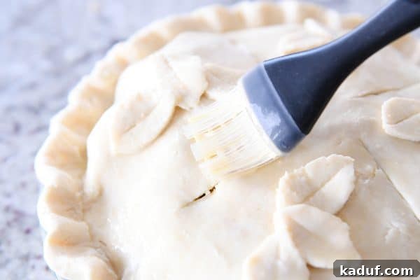 Thanksgivings Beloved Apple Cranberry Pie 13 Brushing egg wash on top of apple cranberry pie.
