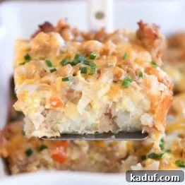 Square of tater tot breakfast casserole scooped on metal spatula.