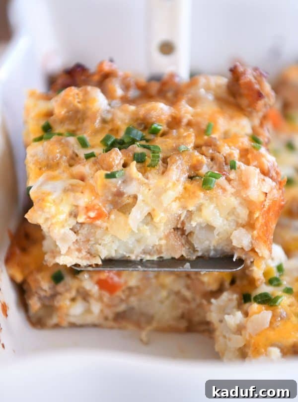 Dreamy Overnight Tater Tot Breakfast 3 Square of tater tot breakfast casserole scooped on metal spatula.
