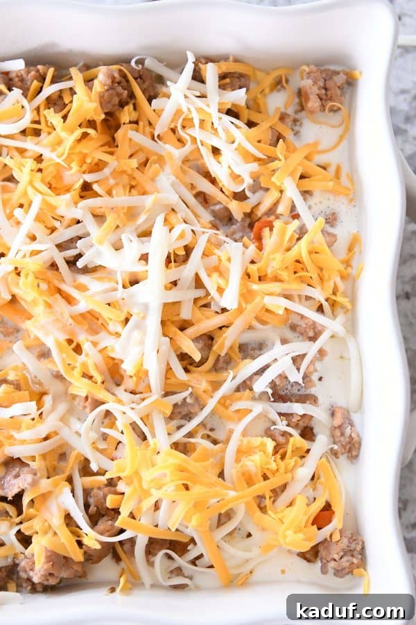 Dreamy Overnight Tater Tot Breakfast 8 Tater tot breakfast casserole with egg mixture poured on top.