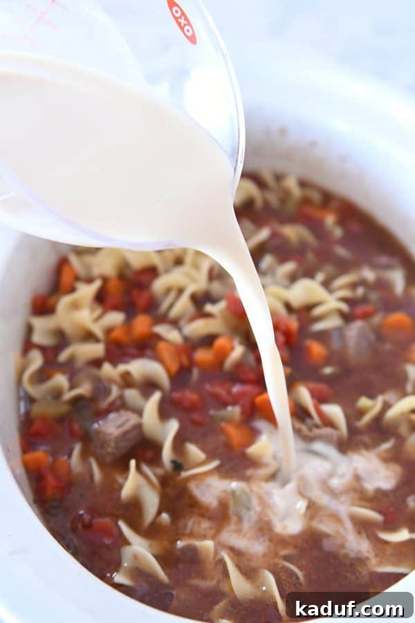 Hearty Slow Cooker Beef and Veggie Noodle Soup 9 Adding a cornstarch slurry to the slow cooker beef vegetable noodle soup to thicken it.